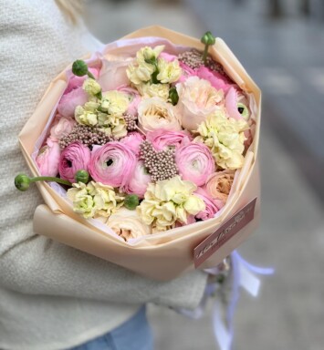 Bouquet with ranunculus, garden roses and matthiola in pastel yellow-pink shades