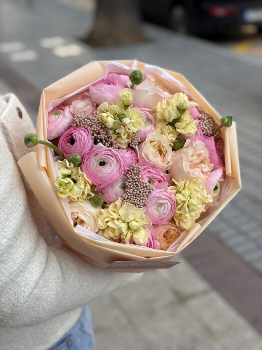 Bouquet with ranunculus, garden roses and matthiola in pastel yellow-pink shades